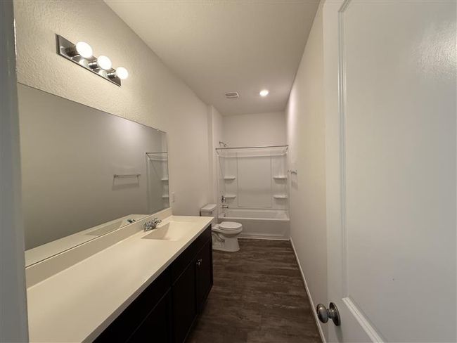 Full bath featuring toilet, vanity, wood finished floors, and shower / bath combination | Image 4