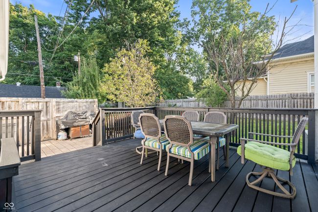 wooden terrace featuring a fenced backyard, outdoor dining space, and grilling area | Image 50