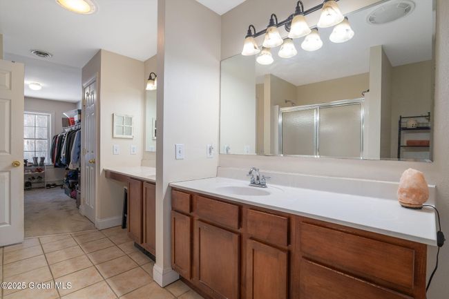 Primary en-suite bath featuring 2 separate vanities, walk in shower, whirlpool tub and walk in closet | Image 25