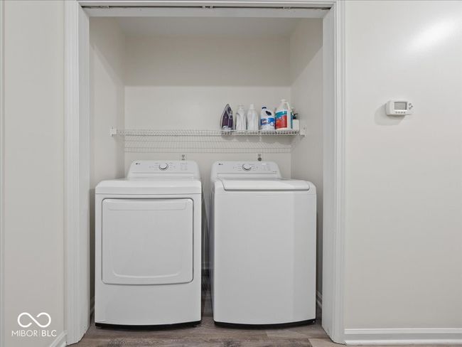 Laundry area featuring hardwood finished floors, and washing machine and dryer | Image 17