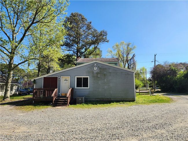 Rear access to building from the graveled parking lot with dual side driveway for entrance/exit. | Image 6