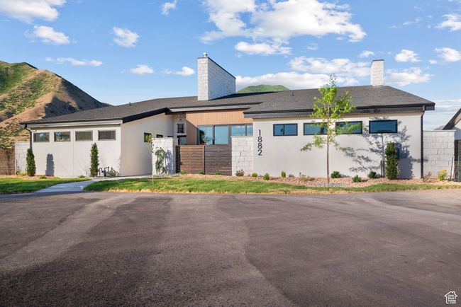View of front of home with a chimney, stucco siding, and a mountain view | Image 4