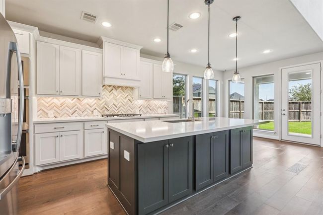 Enjoy stainless steel appliances, granite counters, a gas cooktop, and a large island ideal for casual meals or entertaining | Image 4