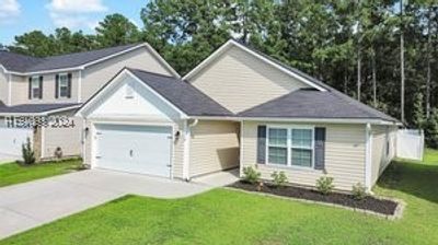 View of front of property featuring a front yard and a garage | Image 1