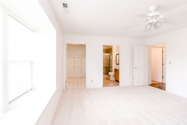 Your primary suite features a walk-in closet, ceiling fan, brand new carpet and a window seat. | Image 14