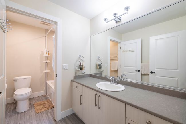 Bathroom with vanity, wood finished floors, visible vents, baseboards, and toilet | Image 13