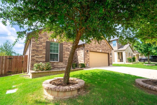View of front facade featuring brick siding, an attached garage, and driveway | Image 32