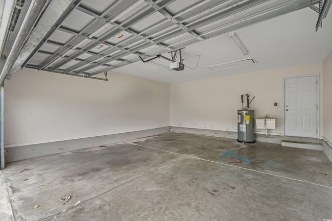 Garage featuring electric water heater, a garage door opener, and a sink | Image 37