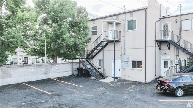 View of building exterior with stairway and uncovered parking | Image 25