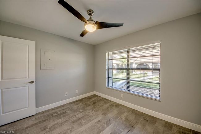 Spare room with ceiling fan, light wood-type flooring, and electric panel | Image 9