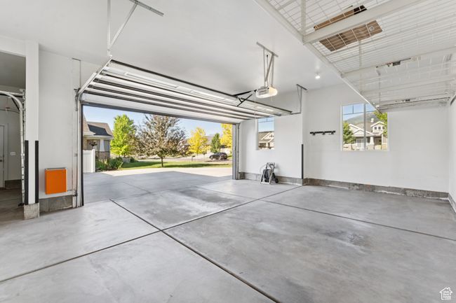 Garage with a garage door opener and baseboards | Image 38