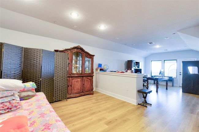 Bedroom featuring visible vents, vaulted ceiling, recessed lighting, and light wood finished floors | Image 16