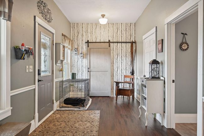 This expansive 30x8 foyer was recently updated with a lovely barn door, wallpaper, fresh paint, and brand new flooring. It was part of the 1993 addition. | Image 8