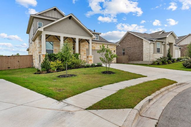 View of front of home featuring stone siding, driveway, board and batten siding, and an attached garage | Image 37