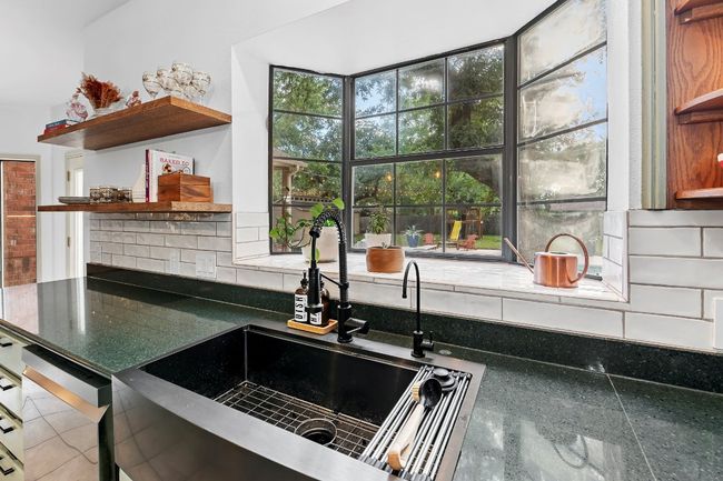 Kitchen featuring open shelves, backsplash, dark countertops, and dishwashing machine | Image 15