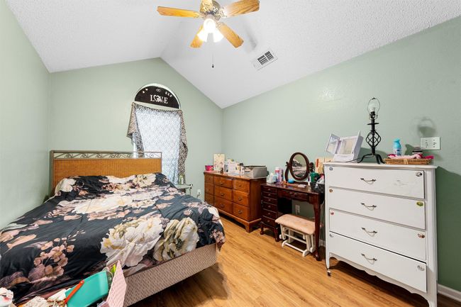 Bedroom featuring light wood-style flooring, vaulted ceiling, and ceiling fan | Image 15