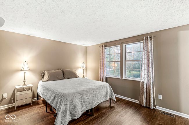 bedroom featuring dark wood-style flooring and a textured ceiling | Image 11
