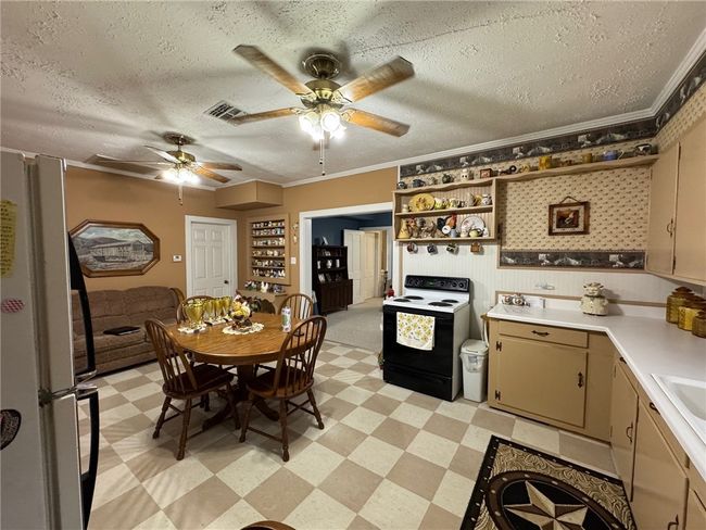 Kitchen featuring electric stove, light flooring, light countertops, a ceiling fan, and a textured ceiling | Image 12