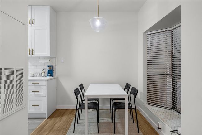 Dining room with light wood-style flooring and a heating unit | Image 10