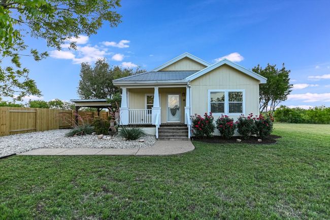 Bungalow with covered porch, fence, metal roof, and a front yard | Image 7