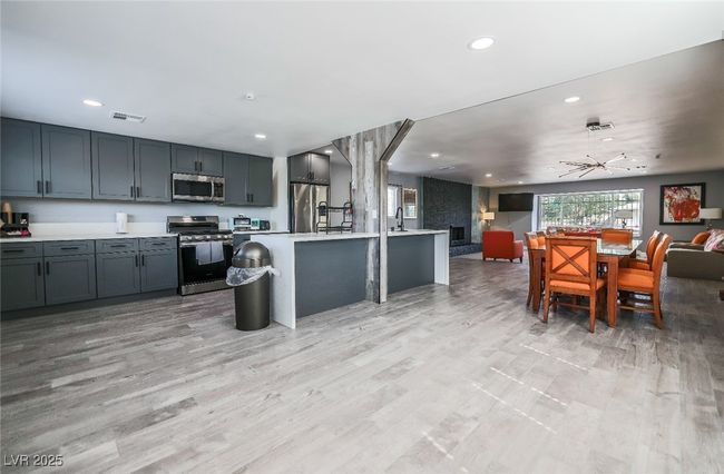 Kitchen with appliances with stainless steel finishes, open floor plan, light countertops, recessed lighting, and light wood finished floors | Image 12