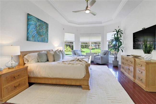 Bedroom featuring crown molding, ceiling fan, a tray ceiling, and dark wood-type flooring | Image 13