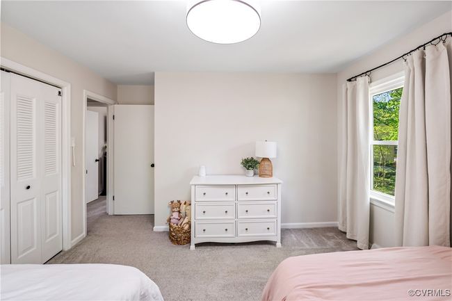 Bedroom with a closet, light carpet, and baseboards | Image 18