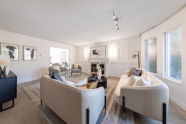 Living room with a fireplace with raised hearth, baseboards, and wood finished floors | Image 22