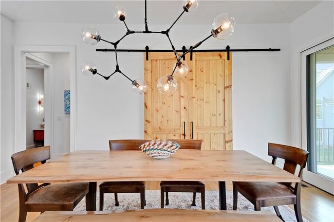 Dining room with a barn door and light wood-type flooring | Image 28