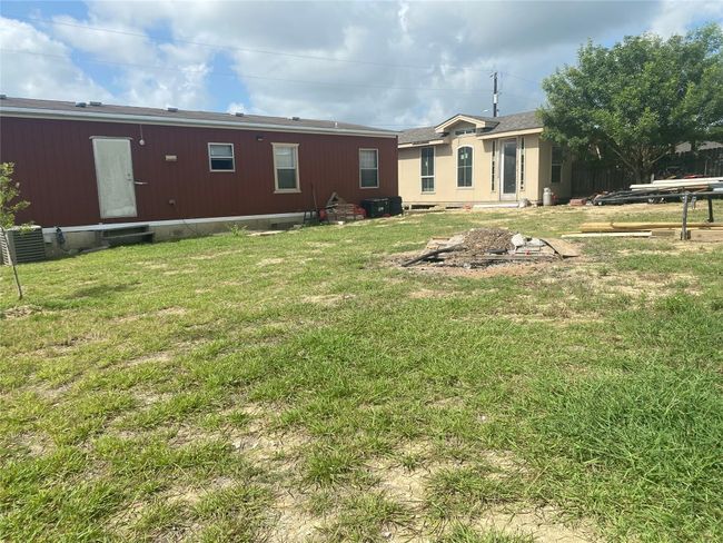 Rear view of property with entry steps and a yard | Image 13