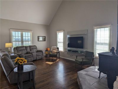 Living room featuring a healthy amount of sunlight, dark wood-type flooring, and high vaulted ceiling | Image 2