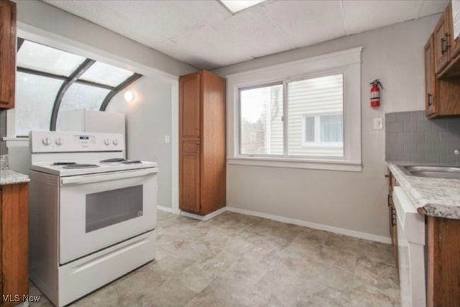 Kitchen featuring electric stove and brown cabinets | Image 8