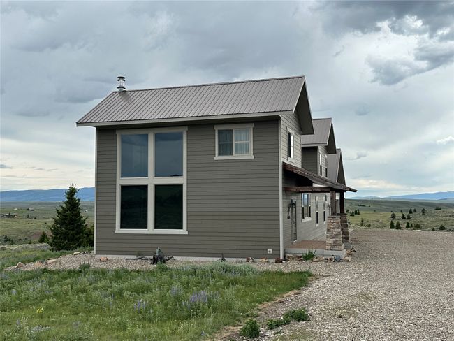 View of property exterior featuring a mountain view and a metal roof | Image 27