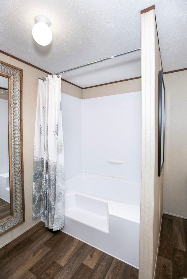 Full bath featuring shower / bathtub combination with curtain, a textured ceiling, and wood finished floors | Image 10