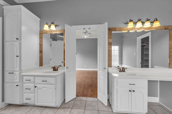 Full bathroom with two vanities, tile patterned flooring, a closet, and ceiling fan | Image 28