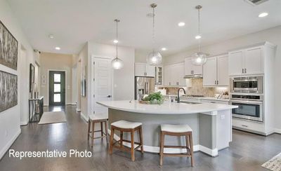 Kitchen featuring appliances with stainless steel finishes, tasteful backsplash, white cabinets, sink, and a kitchen island with sink | Image 2