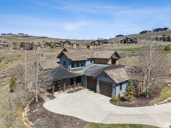 Exterior space featuring covered porch, an attached garage, concrete driveway, and metal roof | Image 42