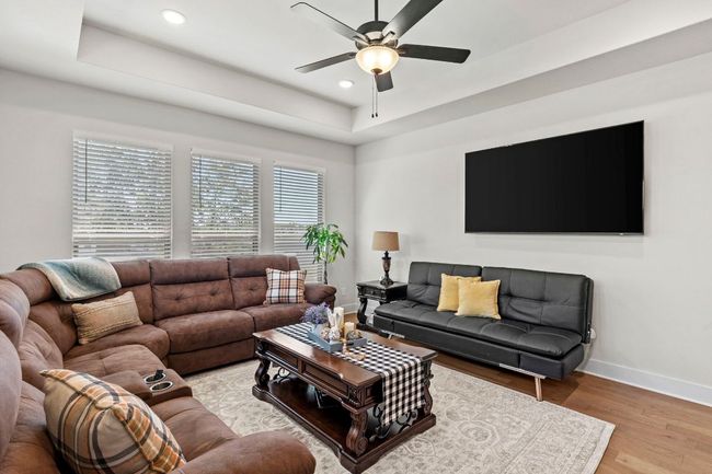 Living area featuring light wood-type flooring, baseboards, a ceiling fan, and recessed lighting | Image 21