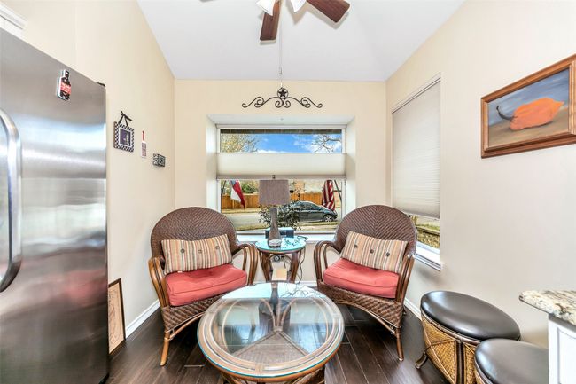 Living area featuring wood finished floors, baseboards, and a ceiling fan | Image 5