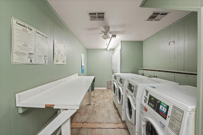 Shared laundry room featuring separate washer and dryer, light wood-style floors, ceiling fan, and wood walls | Image 35