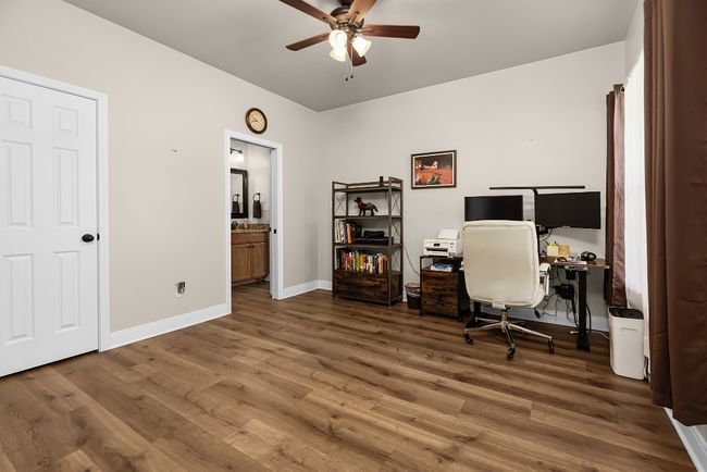 Office space with baseboards, a ceiling fan, and wood finished floors | Image 15