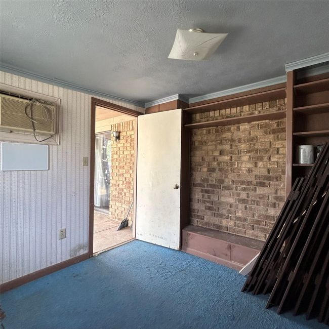 Carpeted empty room featuring a textured ceiling, wooden walls, and ceiling fan | Image 19