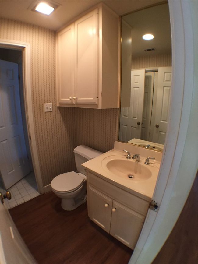 Half bathroom with visible vents, wallpapered walls, wood finished floors, and toilet | Image 15