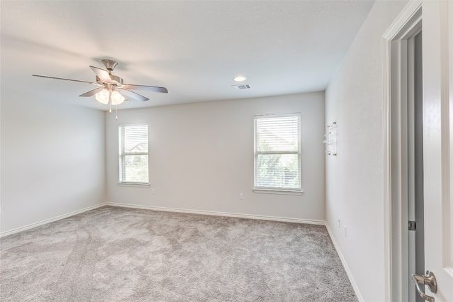 Carpeted empty room with ceiling fan and baseboards | Image 20