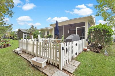 Fenced-in patio area with green space | Image 3