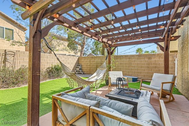 View of patio featuring a pergola, fence, and an outdoor living space | Image 17