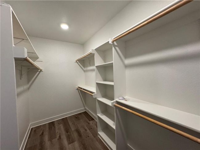 Walk in closet with dark wood-type flooring | Image 59