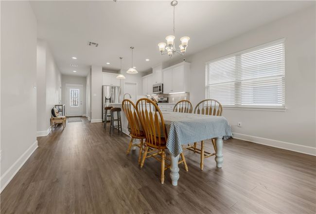 Dining space featuring a chandelier, dark wood-type flooring, and recessed lighting | Image 4