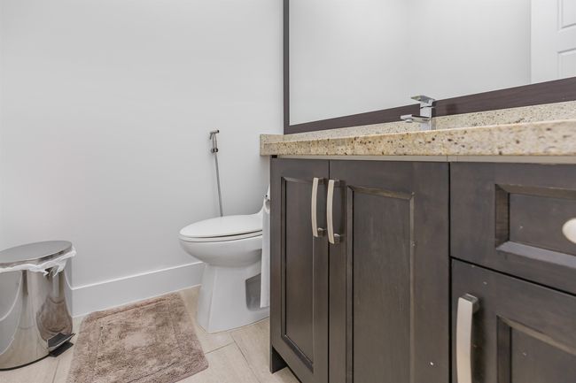 Half bathroom on thhe Main Floor, featuring vanity and tile patterned flooring | Image 10