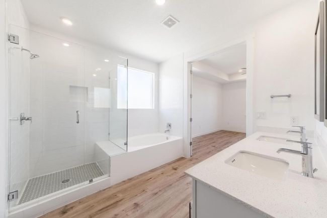 Bathroom featuring wood finished floors, a shower stall, double vanity, a bath, and recessed lighting | Image 13